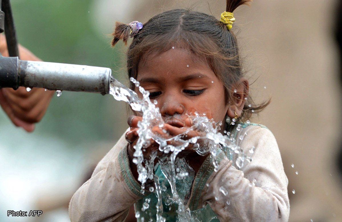 A young Pakistani girl drinks from a hand pump in Lahore on March 27, 2014. More than 2.5 billion people are in need of decent sanitation and nearly one in 10 has yet to gain access to "improved" drinking water, as defined under the UN's 2015 development goals. AFP PHOTO/ARIF ALI